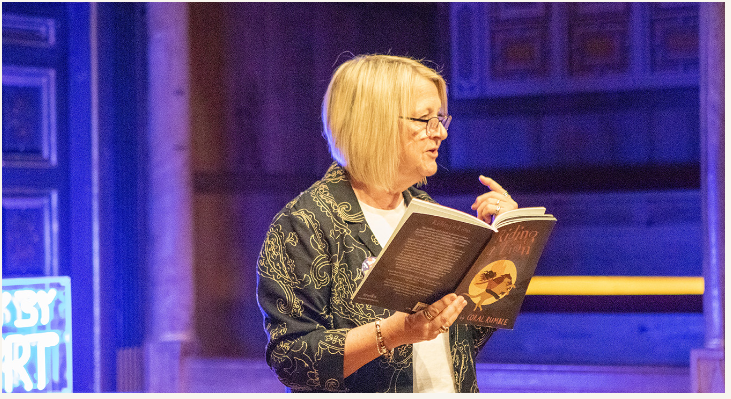 A lady performing a poem at the competition launch of Poetry by Heart.